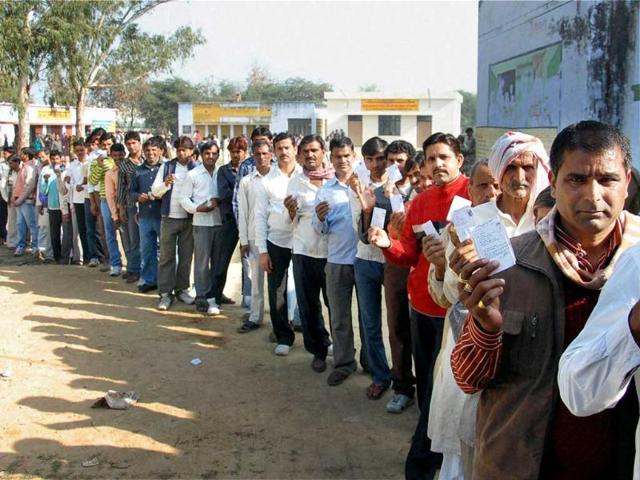 Voters show their identity cards as they wait in a queue to cast votes during the fifth phase of UP assembly polls in Etawah. PTI photo