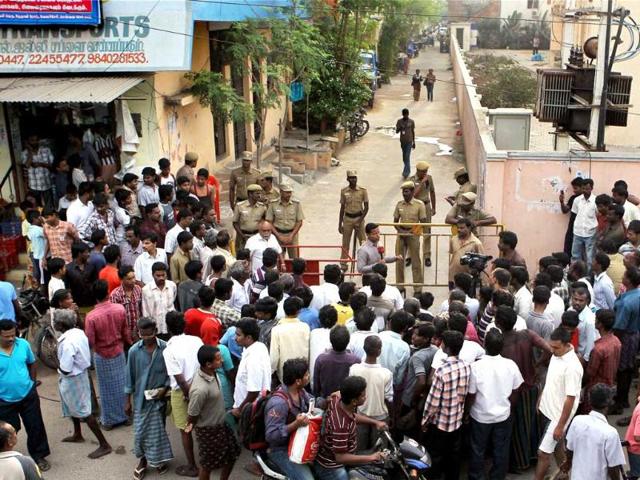 Locals gather near the house from where bank robbers were exchanging fire with the police during an encounter near Velachery in Chennai. The police killed the robbers. PTI/R Senthil Kumar