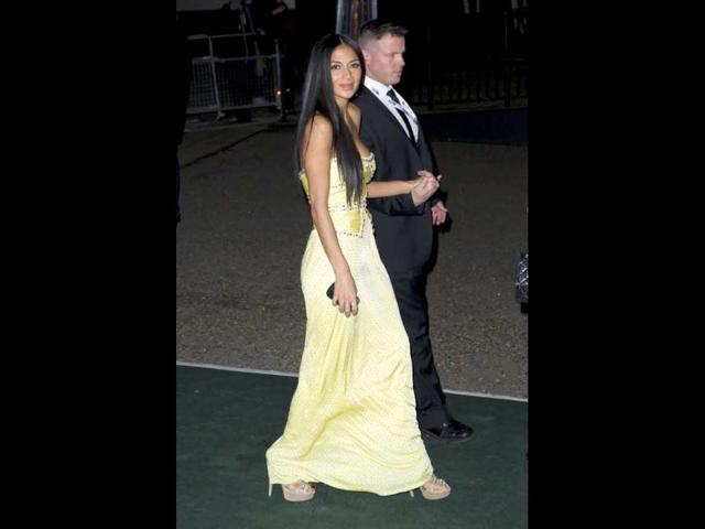 US singer Nicole Scherzinger is escorted by a member of security to the Brit Awards after party.