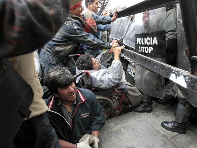 Physically disabled people clash with riot police in the centre of La Paz. Hundreds of physically disabled people after a long way march of 1600 km during a hundred days finally arrived to La Paz to demand Bolivia's President Evo Morales government a support in the form of 3000 bolivianos ($435) allowance for each physically disabled Bolivian, according to local media. Reuters/David Mercado