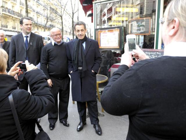 France's President and UMP party candidate for the 2012 French presidential elections Nicolas Sarkozy (R) poses in the street for a souvenir photo as he arrives for a meeting with UMP deputies in Paris. Reuters/Philippe Wojazer