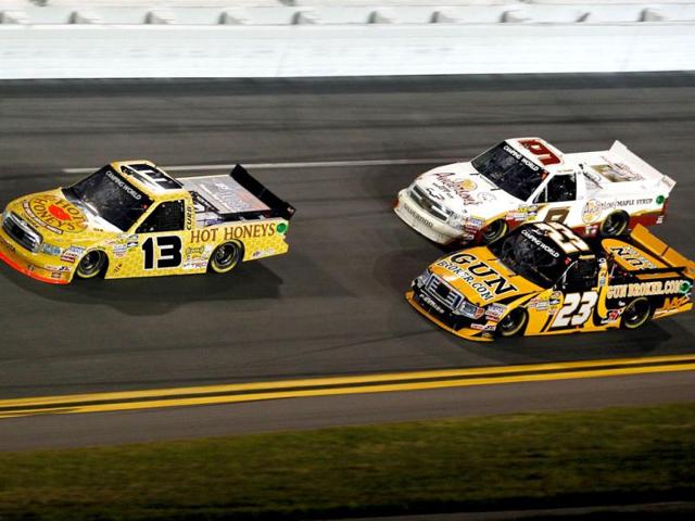 Johnny Sauter, driver of the #13 Hot Honeys Toyota, leads Ron Hornaday Jr., driver of the #9 Anderson's Maple Syrup Chevrolet, and Jason White, driver of the #23 GunBroker.com Ford, during the NASCAR Camping World Truck Series NextEra Energy Resources 250 at Daytona International Speedway in Daytona Beach, Florida. (AFP Photo)