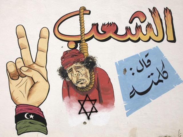 An illustration of Muammar Gaddafi is seen on a wall in Benghazi. (Reuters/Mohammed Salem)