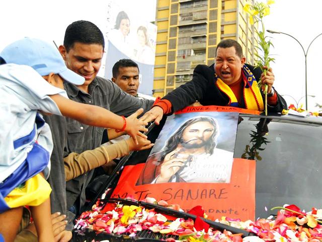 Venezuela President Hugo Chavez greets supporters on his way to the airport, before his departure to Cuba in Caracas. Reuters/Jorge Silva