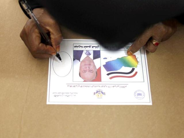 A woman looks at a ballot paper with a photo and name of Yemen's Vice President Abd-Rabbu Mansour Hadi as she casts her vote during the presidential elections in the southern Yemeni port city of Aden. Yemen sealed President Ali Abdullah Saleh's exit from power on Tuesday by electing his deputy, Hadi, to shepherd the country away from the brink of civil war. Reuters/Khaled Abdullah