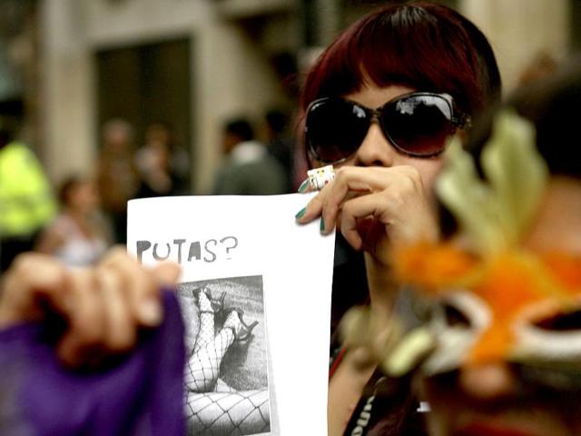 A woman holds a poster with the word Whore on it during a 'March of the whores' held to protest against discrimination and violence against women in Bogota. Reuters/Fredy Builes