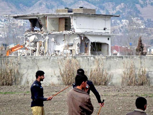 Policemen and residents stand near while demolition work is carried out on the building where al Qaeda leader Osama bin Laden was killed in Abbottabad. Reuters