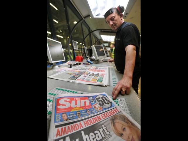 An employee checks copies of the new The Sun on Sunday at the News Printers plant in Broxbourne, outside London. Chairman and CEO of News Corporation, Rupert Murdoch, said he wanted the paper replacing the scandal-hit News of the World to sell over two million copies. (AFP Photo)
