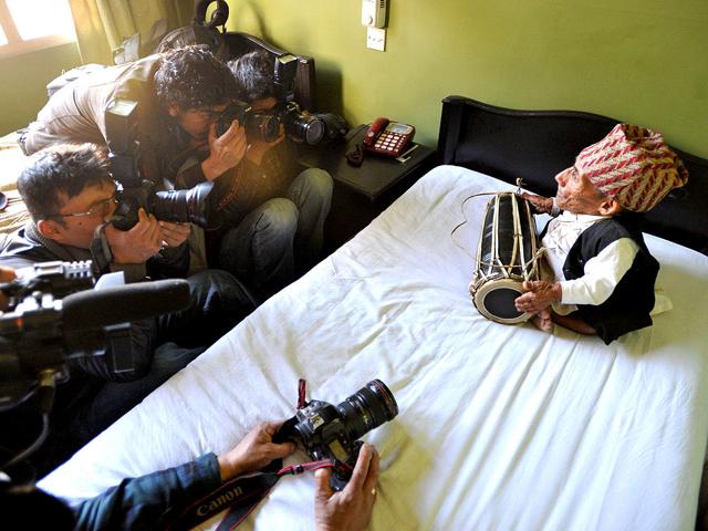 World's shortest man Chandra Bahadur Dangi (R), a 72 year old Nepali, only 21.5 inches (54.6 centimeters) tall, plays a traditional drum in Kathmandu. Dangi left his home in a isolated village in southwestern Nepal to fly to the capital to be measured by Guinness World Records officials. (AFP Photo / Prakash Mathema)