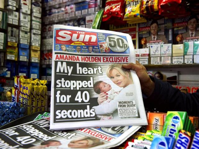 A person holds up Sunday's edition of the new British Newspaper 'The Sun on Sunday' in London. Rupert Murdoch's Sun on Sunday tabloid rolled off the presses for the first time, with a pledge that the paper replacing the scandal-hit News of the World would abide by ethical standards. (AFP photo/Miguel Medina)