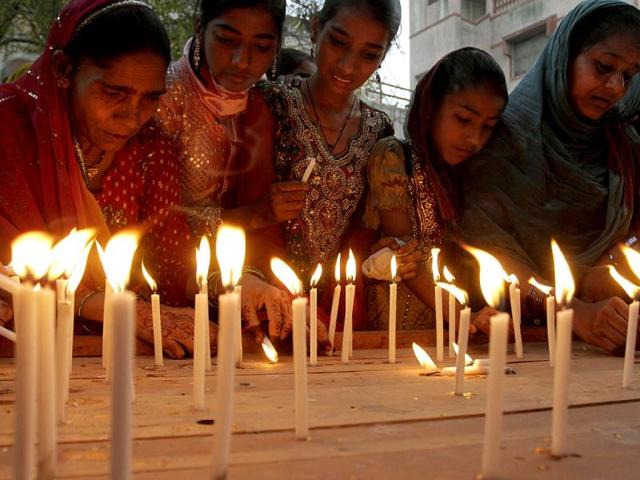 Women light candles during a ceremony in Ahmedabad to mark the 10th anniversary of the Godhra carnage, the country's worst sectarian violence in recent years. AP/Ajit Solanki