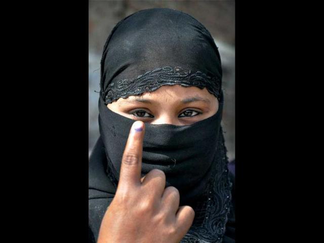 A burqa-clad voter shows her marked finger after casting vote during sixth phase of Uttar Pradesh assembly elections in Mathura. PTI Photo