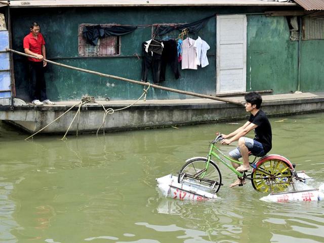 Lei Zhiqian rides a modified bicycle across the Hanjiang River, a tributary of the Yangtze River in Wuhan, Hubei province. The bicycle, equipped with eight empty water containers at the bottom, was modified by Lei's instructor Li Weiguo, who hopes to put his invention into the market. Reuters/China Daily