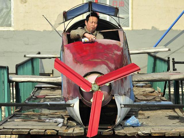 Li Jingchun, a 58-year-old farmer, sprays paints onto his self-made aircraft on top of his house in Xiahe village located in Shenyang, Liaoning province. The 5m long, 1.5m wide plane, mostly made of recycled iron plates, cost the aircraft enthusiast and his family two years and more than 40,000 yuan ($6,349), according to local media. Reuters/Sheng Li