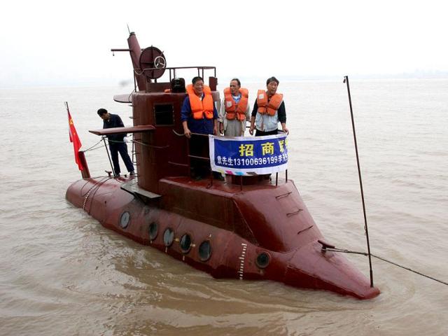 Chinese shipbuilders stand on a submarine designed by a farmer Li Yuming (not pictured) on the Yangtse River in Wuhan, central China's Hubei province. The submarine, 9.8 meters long, two meters wide, and four meters high, was built by some ten shipbuilders in seven months. Maritime Administration of the Yangtse River banned the submarine's trial voyage because it did not undertake any navigational procedure. Reuters/China Newsphoto