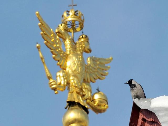 A crow sits next to Russian national emblem, double headed eagle, on top of Historical Museum at the Red Square in Moscow. AFP Photo/Sergei Supinsky