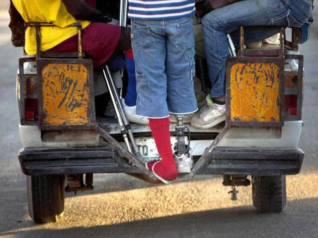 A resident of La Piste camp, Jean Lacroix, 27, whose right leg was amputated due to an injury suffered in a motorcycle accident, rides a public taxi to soccer practice in Port-au-Prince, Haiti. AP Photo/Ramon Espinosa