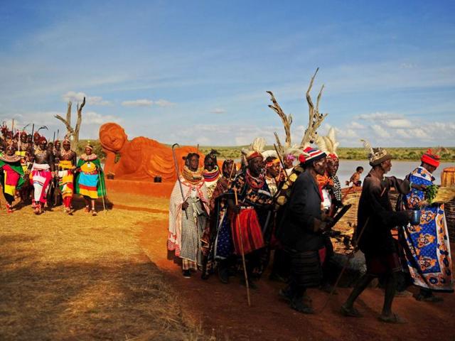 Kenyan tribal elders (R) and Samburu tribemen (L) dance in front of a statue of Buddha at the Gallmann nature conservancy near Kinamba, Laikipia, northern Kenya. High Priest Shinso Ito and a group of Shinnyo-en priests arrived in Kenya to perform a Buddhist fire and water ceremony for the first time ever in Africa. The ceremony was attended by over 300 spiritual leaders and was streamed live on the internet to millions of viewers and devotees globally. The ceremony involved Kenyan tribal elders and members of the Njemps, Pokot Samburu, Kikuyu and Turkana communites. AFP PHOTO/Carl de Souza