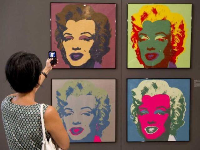 A visitor takes a picture of paintings from Andy Warhol's series "Marilyn Monroe, 1967", during the "I want to be Marilyn Monroe" exhibition, at the Cinemateca Brasileira in Sao Paulo, Brazil.(AFP photo/ Nelson Almeida)
