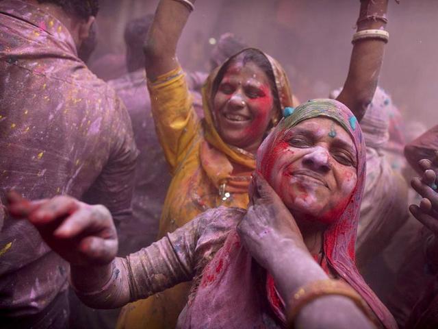 Devotees smear color on each other while celebrating Holi at the Banke Bihari temple in Vrindavan. AP Photo/Kevin Frayer