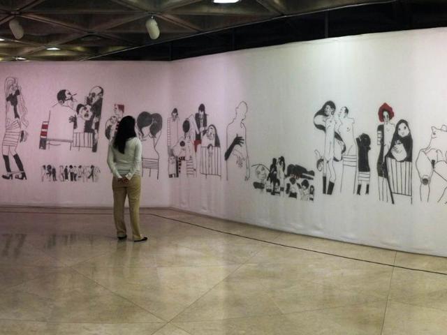 A visitor watches "City and Stories", part of the exhibition by Costa Rican artists held at the National Gallery in San Jose on March 7, 2012. The exhibition is part of the "Museums and Galleries Route" during the XIII International Arts Festival to be held in San Jose from 1 to 25 March. (AFP Photo)