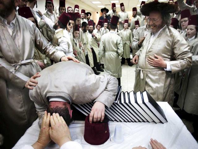 Utra-orthodox Jewish men celebrate Purim inside a synagogue in Jerusalem. The Jewish holiday of Purim celebrates the Jews' salvation from genocide in ancient Persia, as recounted in the Scroll of Esther. (AP Photo/Bernat Armangue)