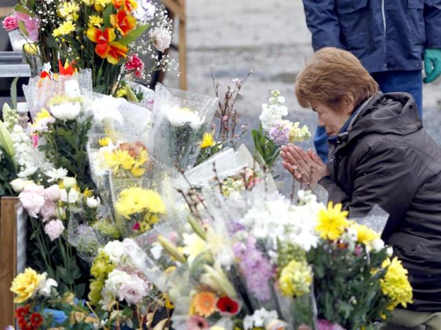 A woman prays for students of Okawa Elementary School who died in the March 11, 2011 earthquake and tsunami at the school in Ishinomaki, Miyagi prefecture. (Reuters/Toru Hanai)