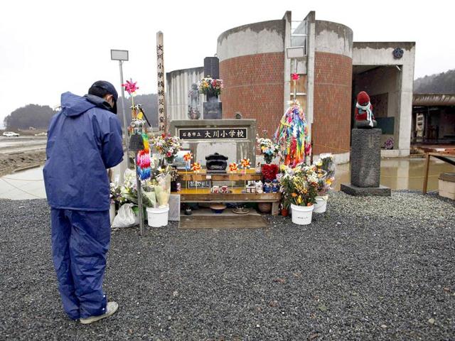 A man prays for students of Okawa Elementary School who died in the March 11, 2011 earthquake and tsunami at the school in Ishinomaki, Miyagi prefecture. (Reuters/Toru Hanai)