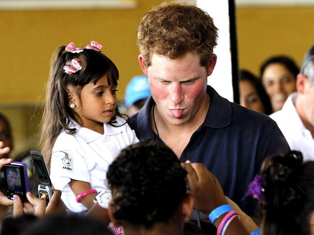Prince Harry playfully sticks out his tongue as he poses for a photo during his visit to the Complexo do Alemao slum, in Rio de Janeiro, Brazil. (AP Photo/Silvia Izquierdo)