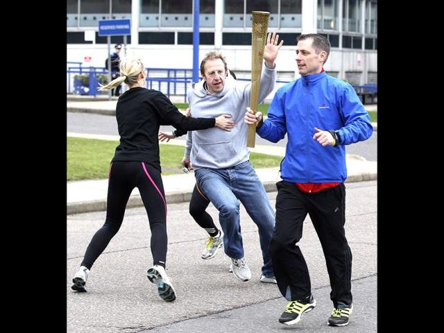 Police officers designated to protect the Olympic torch, the Olympic Torch Security Team, demonstrate to the media how they will protect the torch bearers and Olympic flame during the torch relay's progress through Britain, at the Metropolitan Police training school in Hendon, north London.(Reuters)