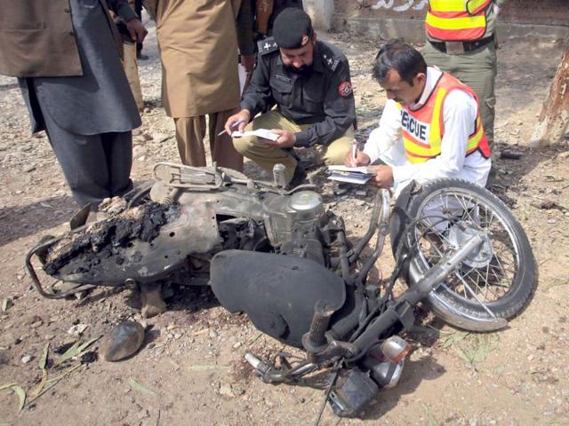 Police and rescue workers inspect a damaged motorbike at the site of a suspected suicide bomb attack in the outskirts of Peshawar. Reuters/Fayaz Aziz