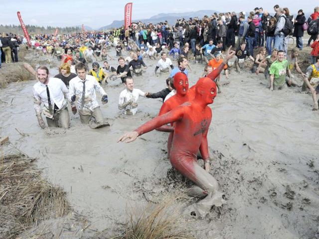 Competitors run through muddy water during the Strongman Run in Thun, Switzerland. AP Photo/Keystone/Peter Schneider