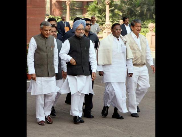 Prime Minister Manmohan Singh, flanked by parliamentary affairs minister Pawan Kumar Bansal and ministers of state V Narayanasamy (R) and Harish Rawat, arrives at Parliament House on the first day of the budget session, in New Delhi on Monday. Vijay Kumar Joshi