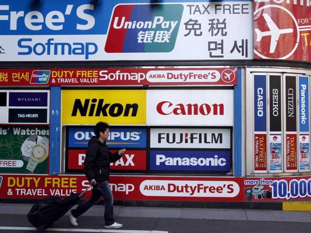 A-man-walks-past-an-advertisement-board-featuring-Chinese-bank-card-UnionPay-at-the-electronic-shopping-district-Akihabara-in-Tokyo-Business-sentiment-among-Asia-s-top-companies-improved-dramatically-in-the-first-quarter-following-three-straight-quarterly-declines-buoyed-by-signs-of-recovery-in-the-US-and-some-steadying-of-Europe-s-debt-crisis-Reuters
