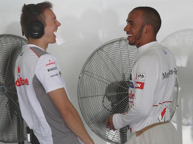 McLaren Formula One driver Lewis Hamilton of Britain jokes with a teammate as he waits in the team garage during the first practice session at the Malaysian Formula One Grand Prix at Sepang, Malaysia. (AP Photo/Dita Alangkara)