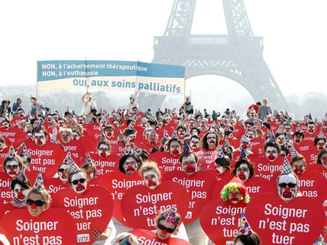 People take part in a flash mob event organized by the 'Alliance VITA' association as part of their tour of France in solidarity with elderly people and against euthanasia in front of the Eiffel tower in Paris. AFP Photo/Kenzo Tribouillard