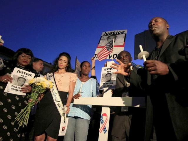 Marc Booker, of Sanford, leads a prayer during the candlelight vigil at the memorial site outside the gates of the Retreat at Twin Lakes, where Trayvon Martin was shot by neighborhood watch captain George Zimmerman, in Sanford. AP Photo/Julie Fletcher