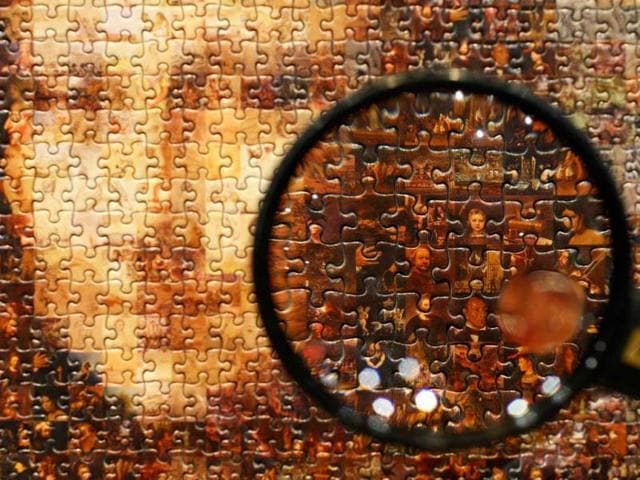 A magnifying glass shows the individual pictures forming a mosaic image of Mona Lisa on a jigsaw puzzle at the International Tokyo Toy Show in Tokyo. (Reuters) 