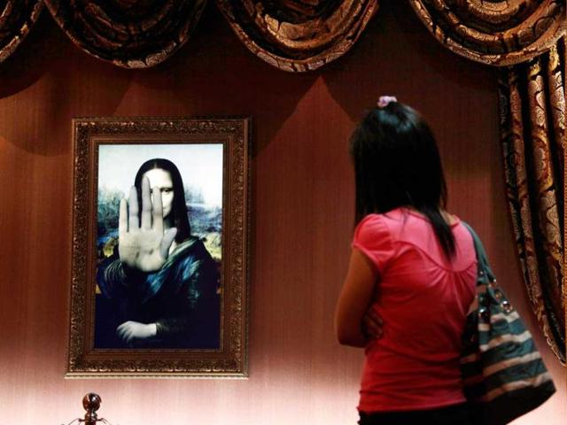 A visitor looks at a three-dimensional, holographic version of the 16th century portrait "Mona Lisa" by Leonardo da Vinci as it indicates not to move any closer in Beijing's Alive Gallery.(Reuters) 