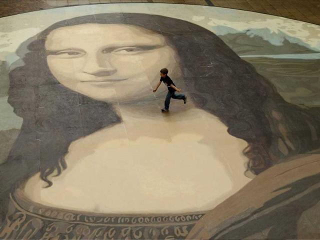 A boy runs across a giant copy of the Mona Lisa as it is unveiled in Wrexham, north Wales. The giant version of Leonardo da Vinci's masterpiece measuring 17.5 metres across and 50 times bigger than the original, is an attempt to produce the largest ever reproduction of the painting. (Reuters) 
