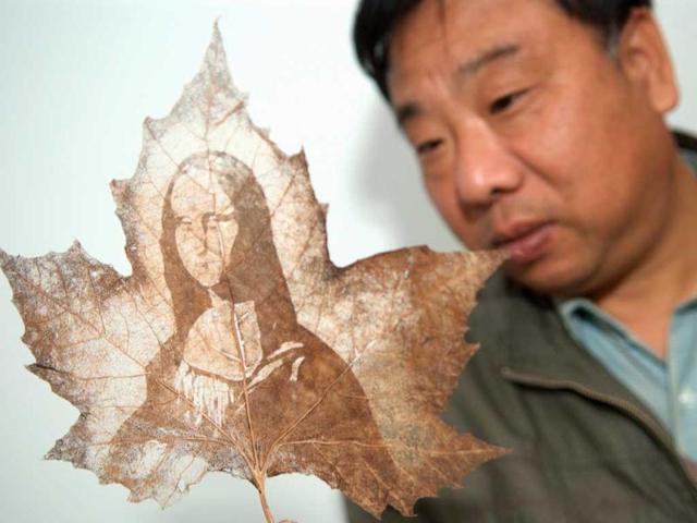 Folk artist Yu Guiming shows a Chinese parasol leaf engraved with the image of Leonardo da Vinci's Mona Lisa in Shangcheng county, Henan province. Yu, 57, who is skilled at drawing, started carving on leaves in 2009. (Reuters) 