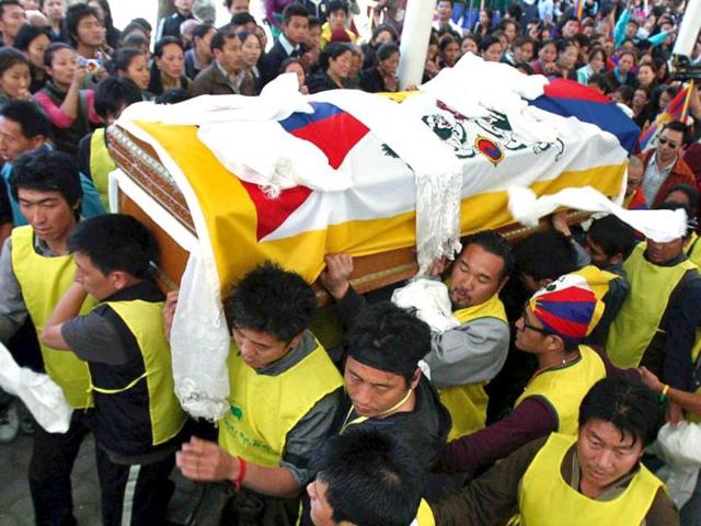 Tibetan exiles carry a coffin containing the body of Jamphel Yeshi for cremation inside the Tsuglagkhang temple in Dharamsala. (Reuters)
