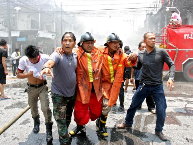Thai rescue workers help an injured fireman at the scene of a car bomb blast in Thailand's southern restive province of Yala. AFP Photo/Muhammad Sabri