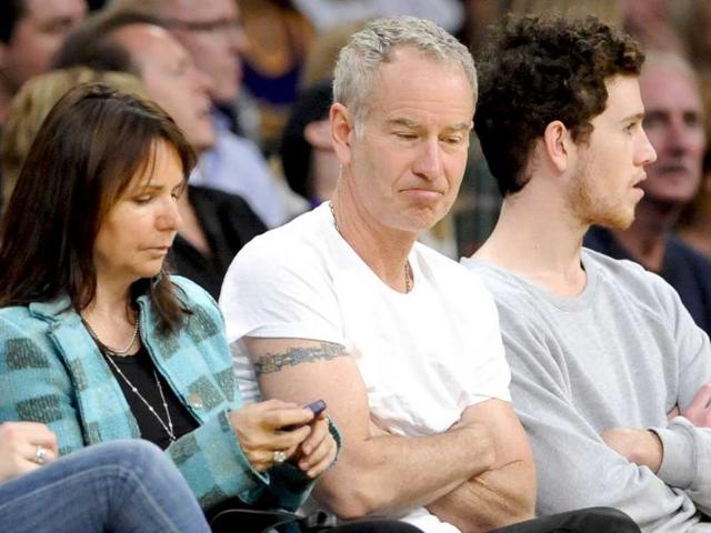 Former tennis great John McEnroe, center, and wife singer Patti Smyth attend an NBA basketball game between the New Orleans Hornets and the Los Angeles Lakers, in Los Angeles. AP/Gus Ruelas
