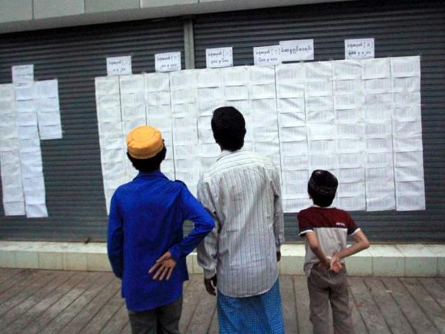 People look at a list with candidates' names, at a polling station in Yangon. AFP/Ye Aung Thu