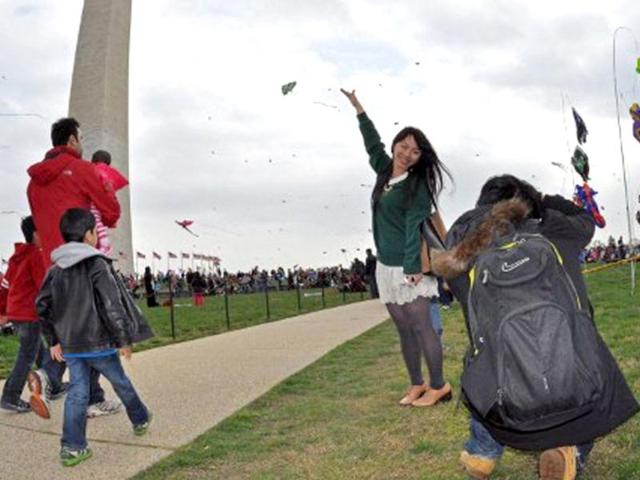 A Japanese tourist poses in front of the Washington Monument during the annual Blossom Kite Festival in Wasington, DC. The event is part of the National Cherry Blossom Festival which this year celebrates 100 years of friendship between Japan and the United States. AFP PHOTO/Eva Hambach