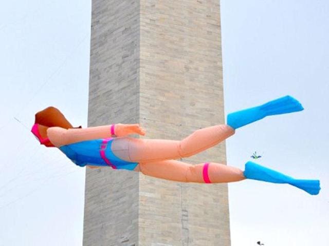 A scuba diver kite floats past the Washington Monument during the annual Blossom Kite Festival in Washington, DC. The event is part of the National Cherry Blossom Festival.