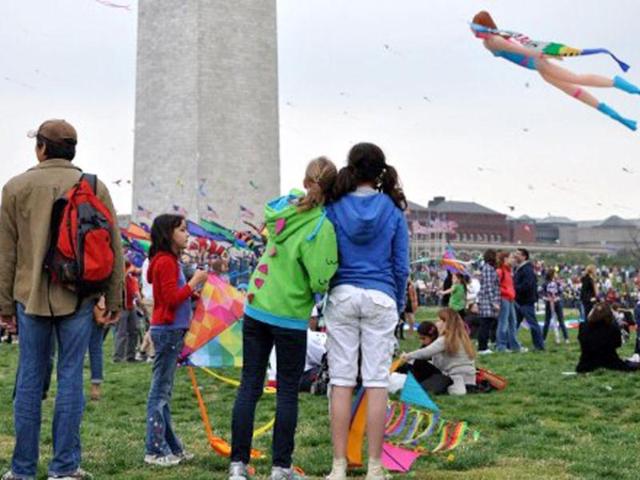 Girls watch a scuba diver kite float past the Washington Monument during the annual Blossom Kite Festival in Wasington, DC. The event is part of the National Cherry Blossom Festival which this year celebrates 100 years of friendship between Japan and the United States. AFP PHOTO/Eva Hambach