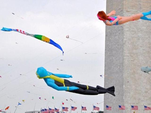 Scuba diver kites float past the Washington Monument during the annual Blossom Kite Festival on the National Mall in Wasington, DC. The event is part of the National Cherry Blossom Festival which this year celebrates 100 years of friendship between Japan and the United States. TOPSHOTS/AFP PHOTO/Eva Hambach
