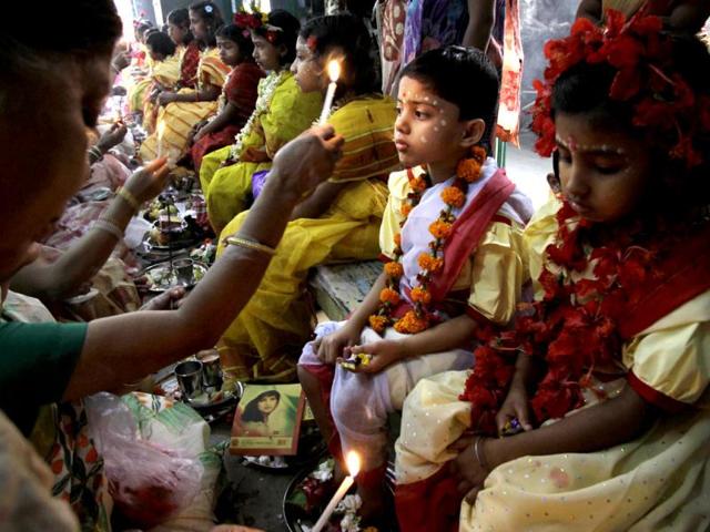 A Hindu devotee worships young girls as they sit together dressed as "Kumari", or living goddesses, during the festival of Ram Navami in Kolkata. (AP Photo/Bikas Das)